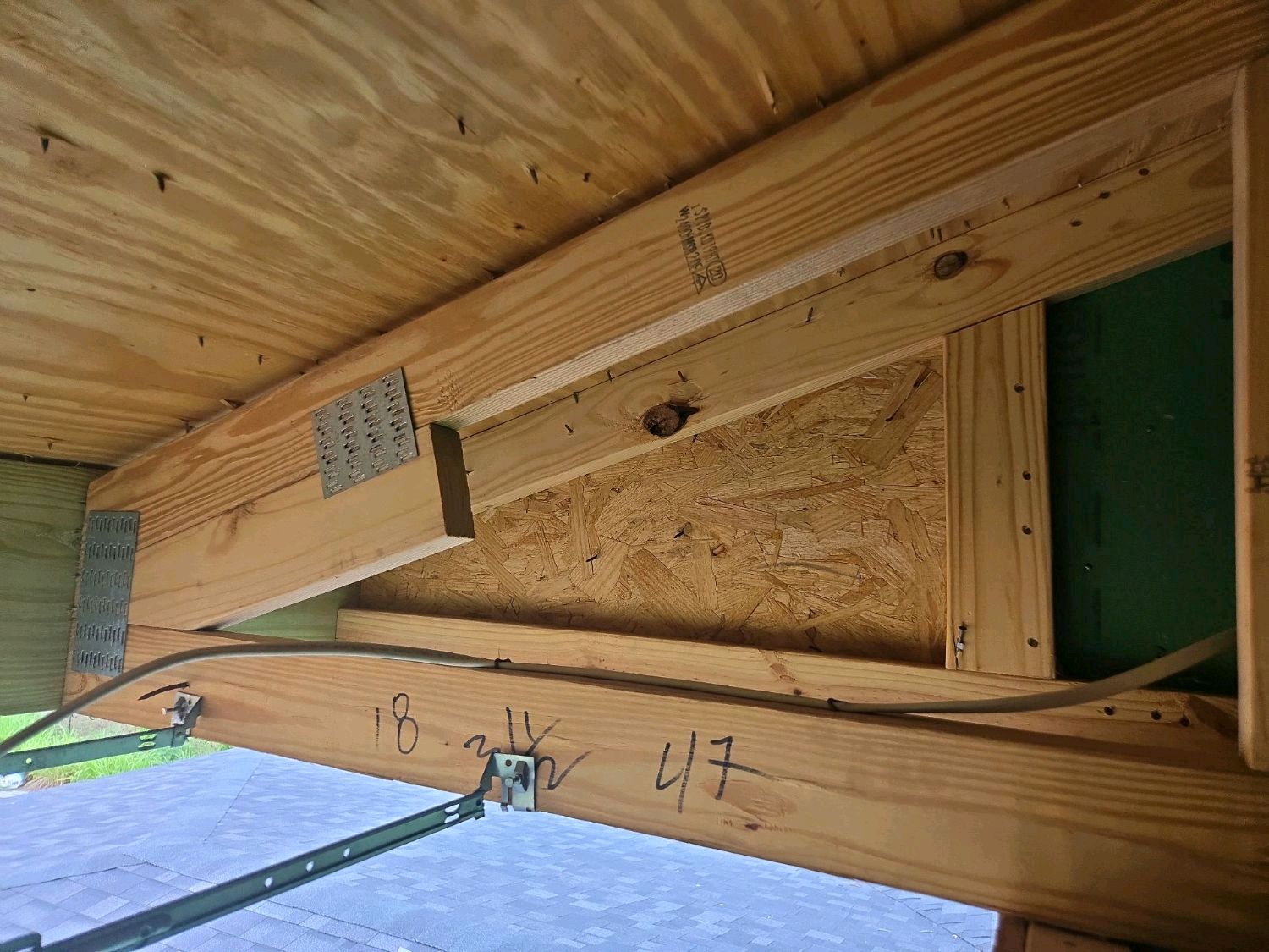 A roof truss bearing on wall framing with no hurricane strap at the bearing point