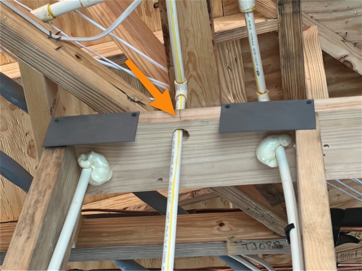 Nail plates over two penetrations, and an arrow at a third pipe through the plate with no protection
