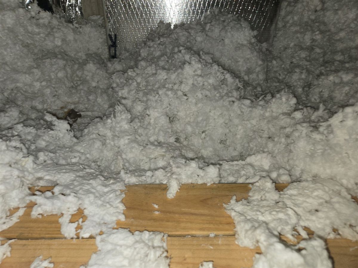 Blown insulation pushed aside after closing, leaving the ceiling drywall bare
